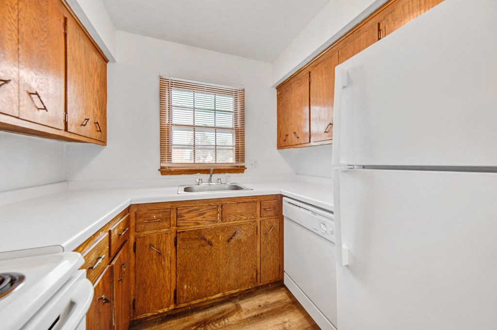 a kitchen with white appliances and wooden cabinets