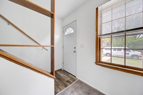 the entrance to a home with a large window and a white door