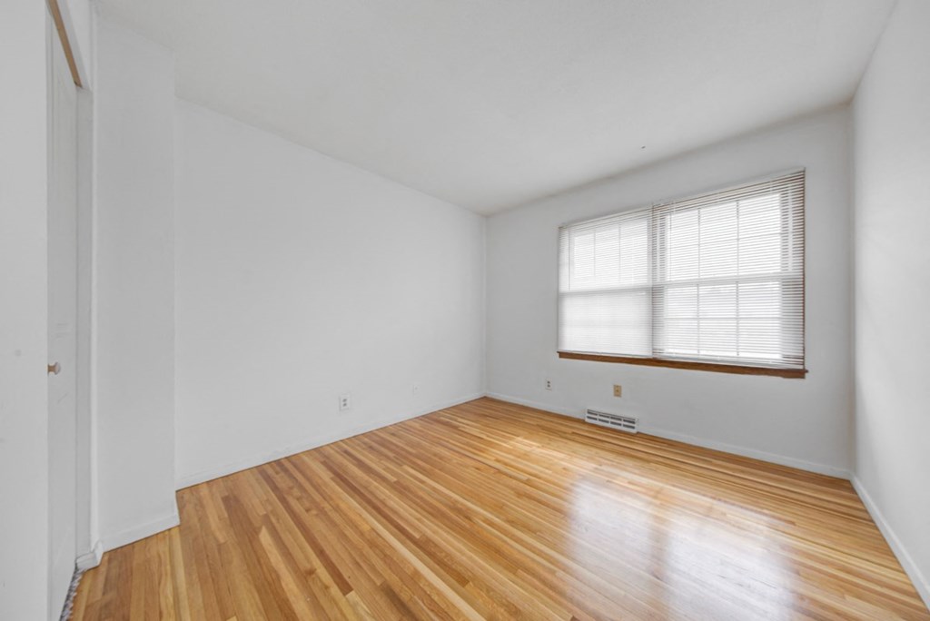 the living room of a house with wood floors and a window