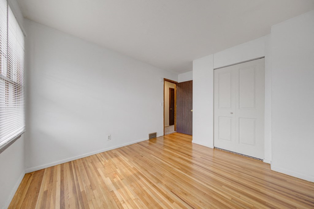 an empty living room with wood floors and a white door