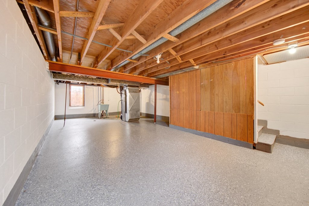an empty garage with a concrete floor and wood ceilings