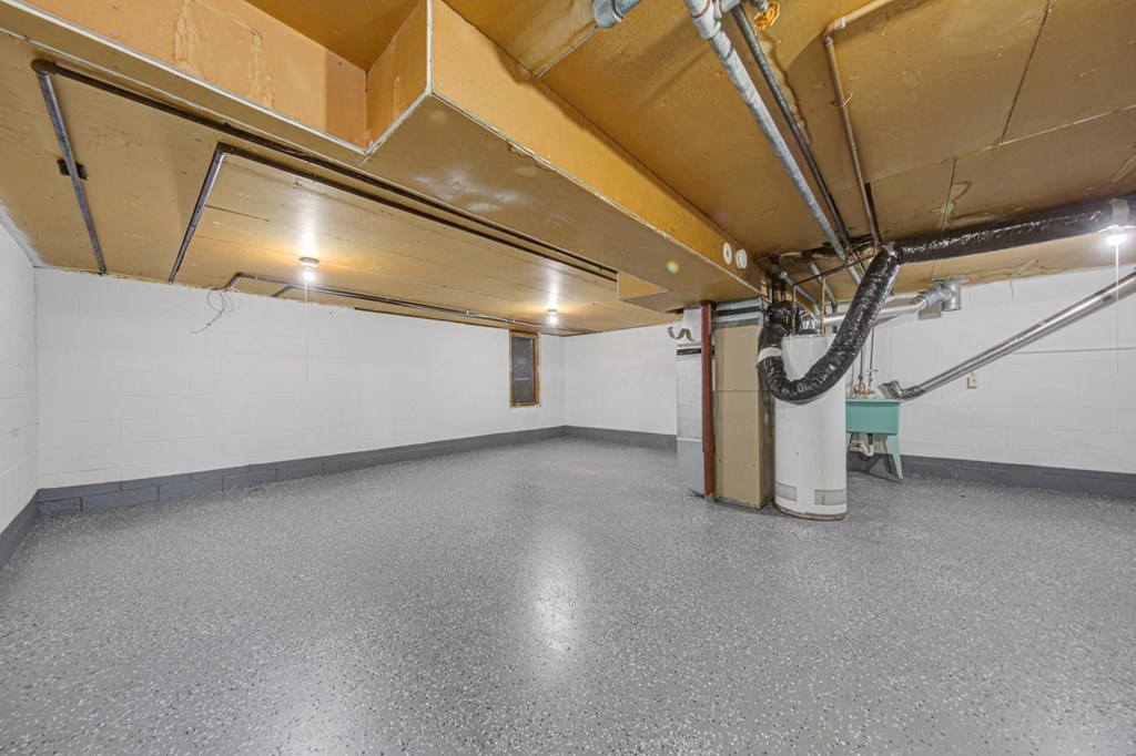 the interior of a garage with a concrete floor and white walls