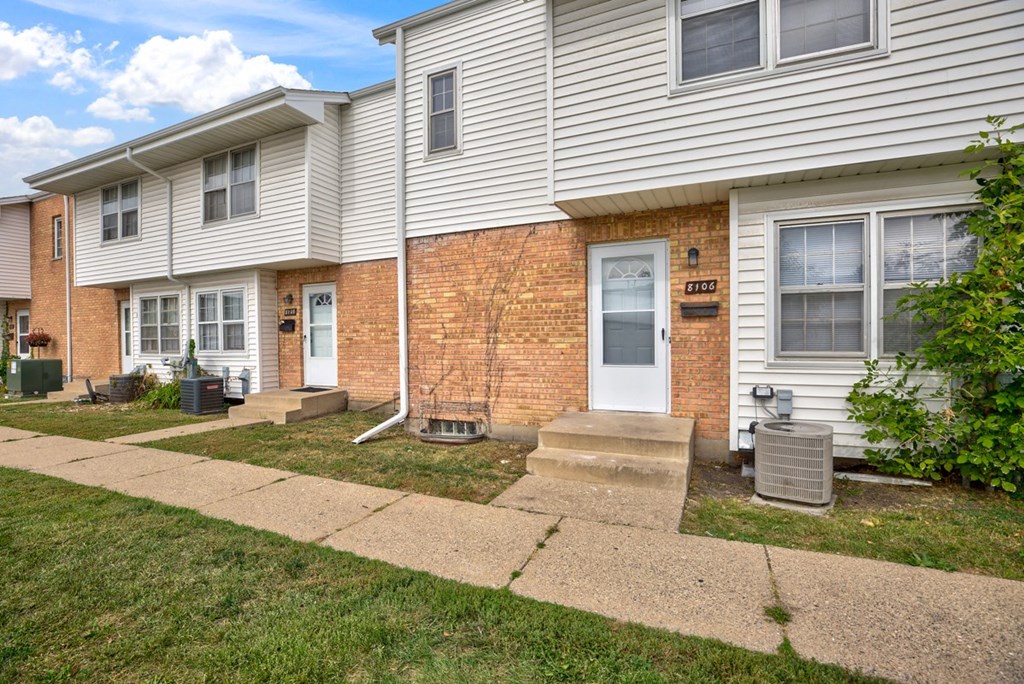 a white house with a sidewalk in front of it