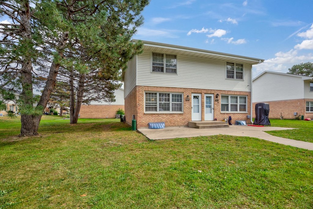 the front of a house with a yard and a sidewalk