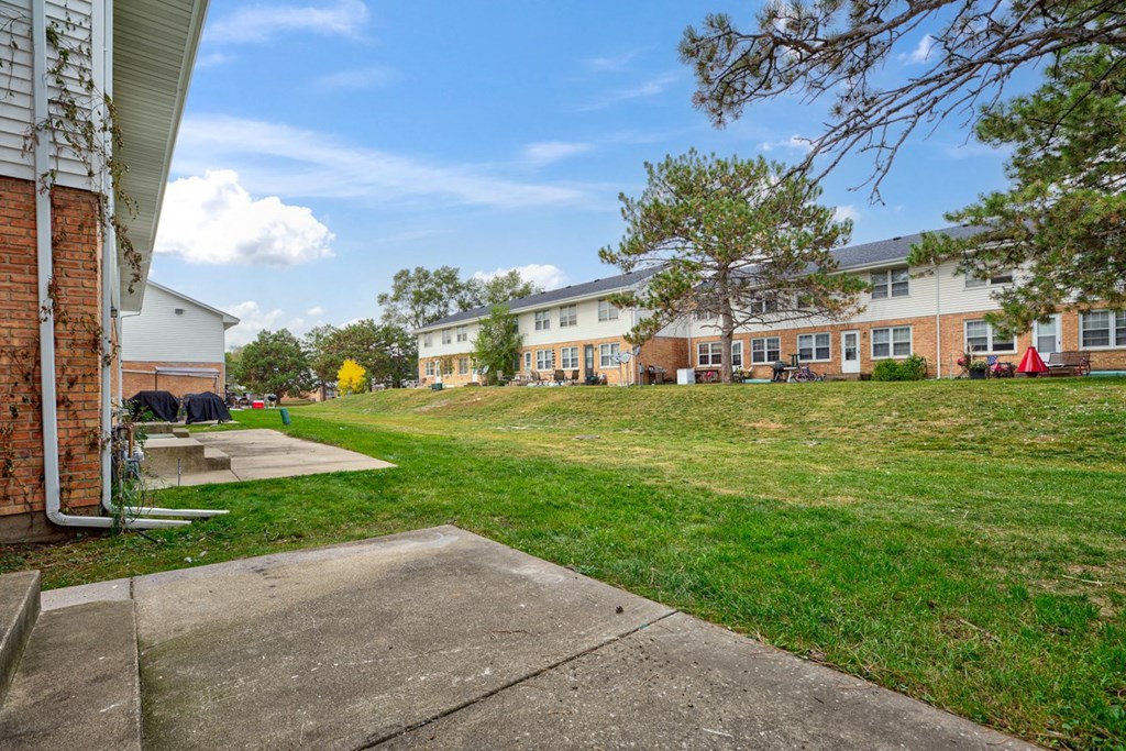 the backyard of a building with grass and concrete sidewalks