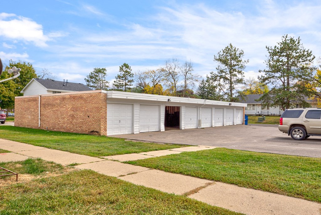 the front of a garage with a car parked in the driveway