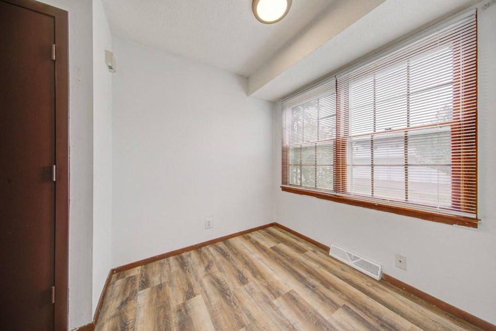 the living room has a large window and wood flooring