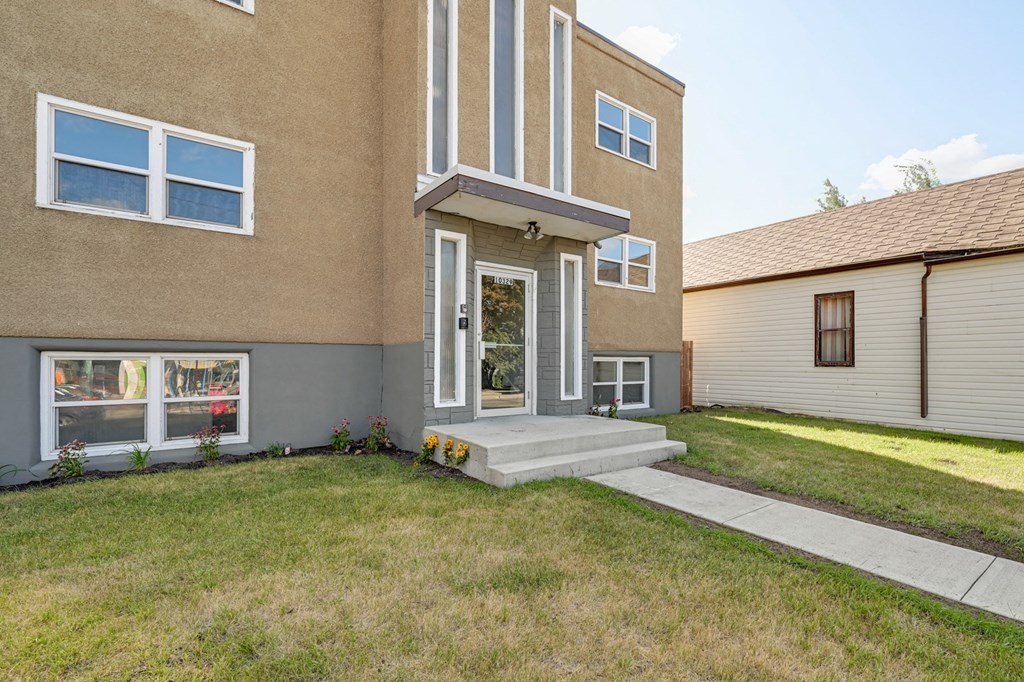 the front of a house with a yard and a sidewalk