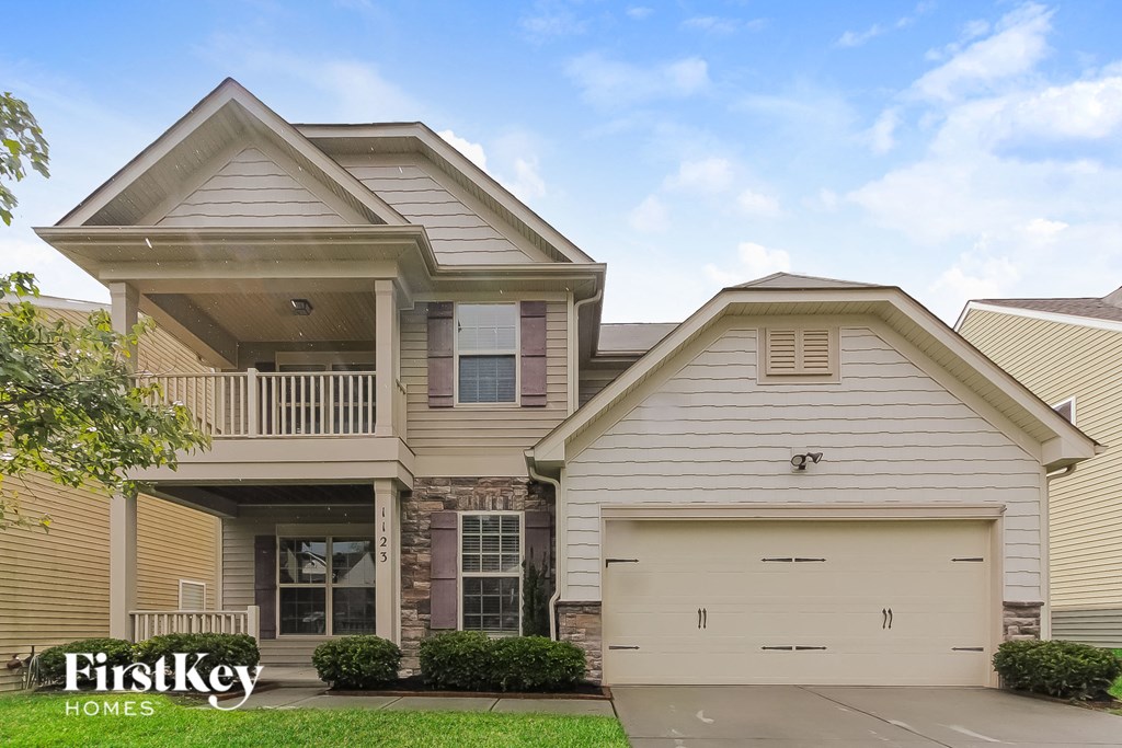a beige house with a garage and a porch