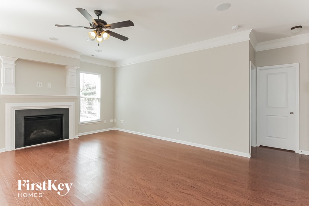 a living room with a fireplace and a ceiling fan