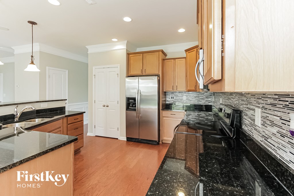 a kitchen with black granite counter tops and stainless steel appliances
