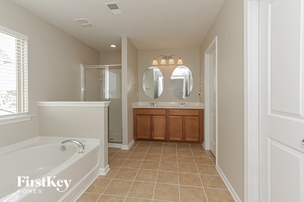 a bathroom with a tub and a sink and a mirror