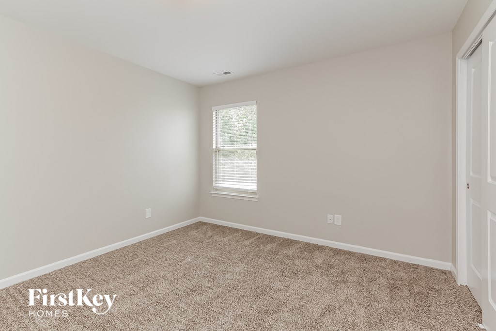 a empty room with carpet and a window