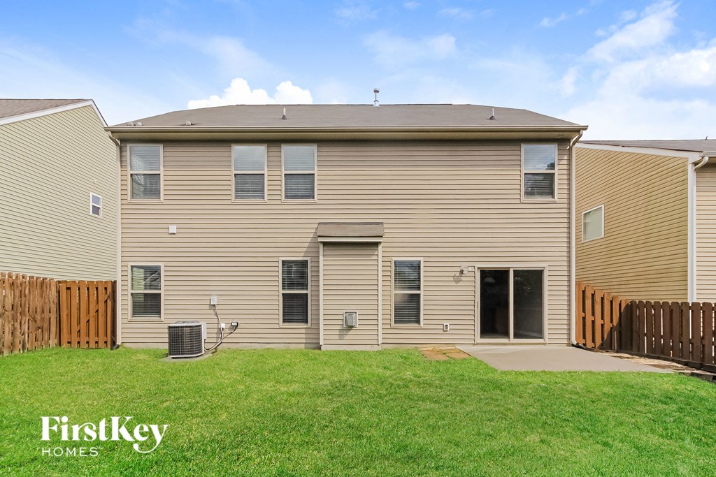 a house with tan siding and a grassy yard