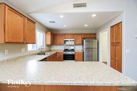 a kitchen with wooden cabinets and a white counter top