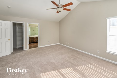 a living room with carpet and a ceiling fan