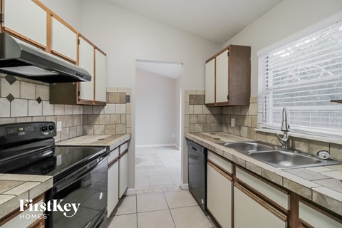 A kitchen with a black stove top oven and a black dishwasher.