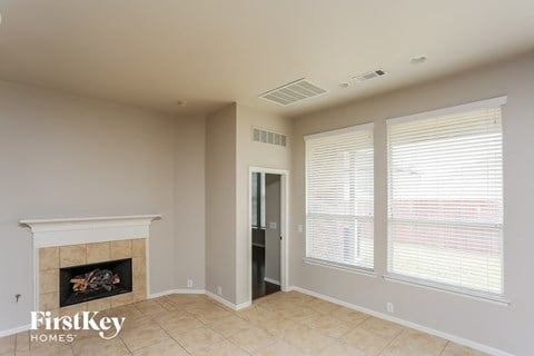 a living room with a fireplace and large windows