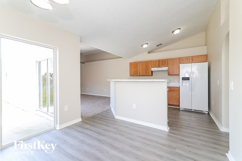 A kitchen with a white counter and wooden cabinets.