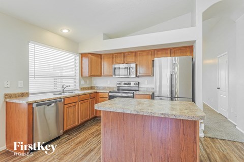 a kitchen with wooden cabinets and stainless steel appliances