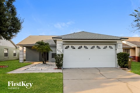 a house with a white garage door and a palm tree