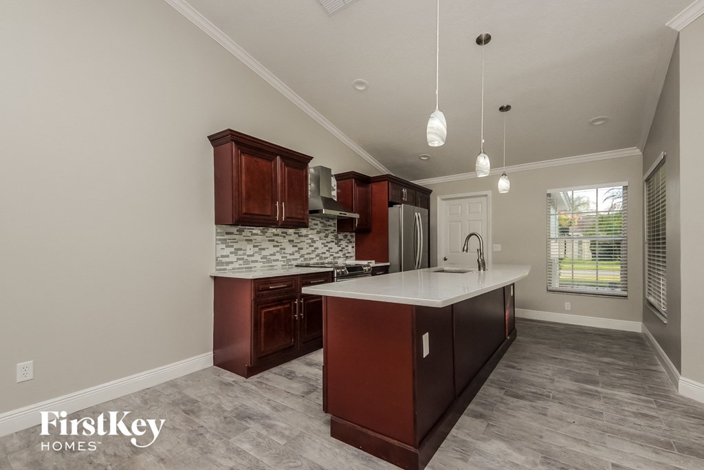 a kitchen with brown cabinets and a white counter top and a sink