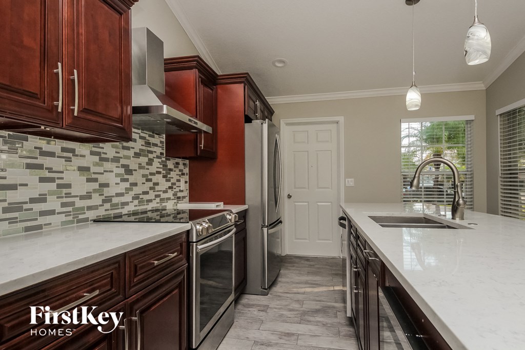 a kitchen with marble counter tops and wooden cabinets