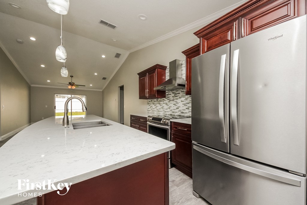 a large kitchen with stainless steel appliances and white counter tops