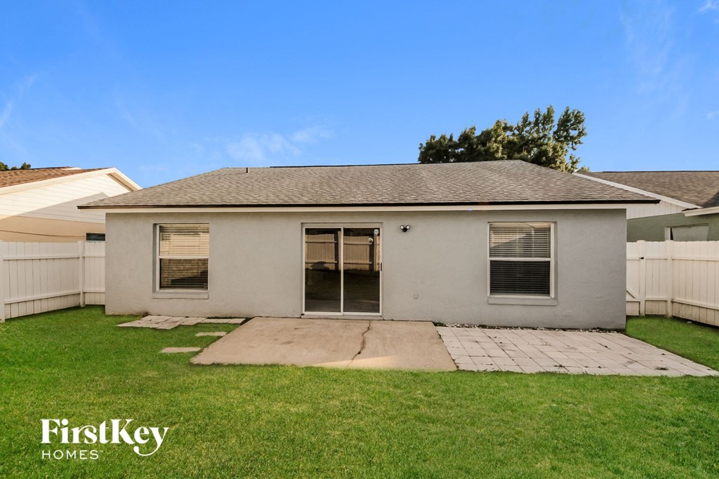 a small white house with a yard and a driveway