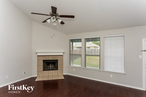 a living room with a fireplace and a ceiling fan