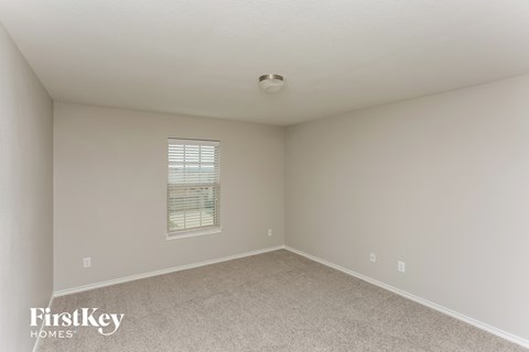 a bedroom with white carpet and a window