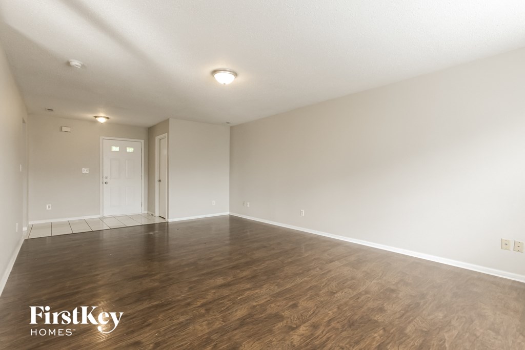 a living room with a hard wood floor and white walls