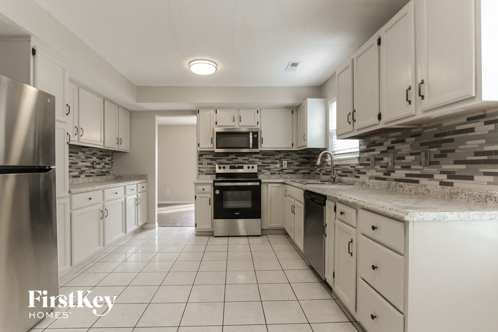 a kitchen with white cabinets and granite counter tops