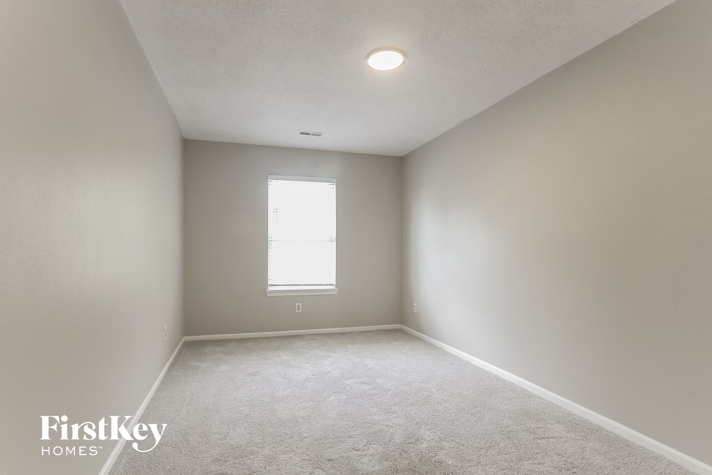 a white room with a window and a white carpet