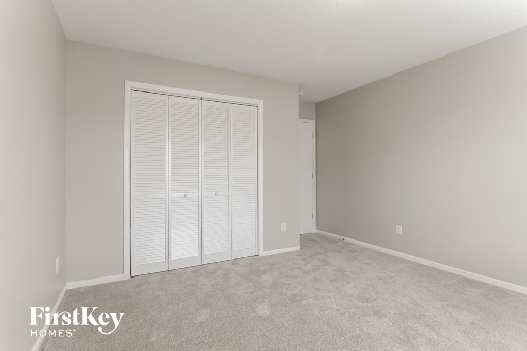 a bedroom with a large closet and a large shuttered door