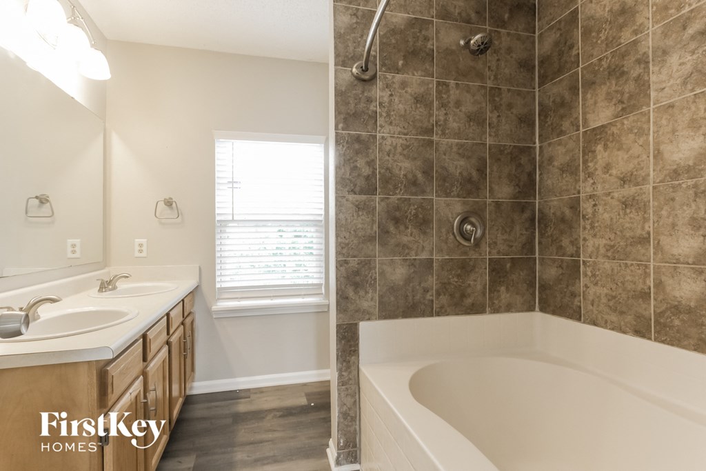 a bathroom with a tub and a sink and a shower