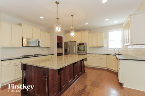 a kitchen with white cabinets and a marble counter top
