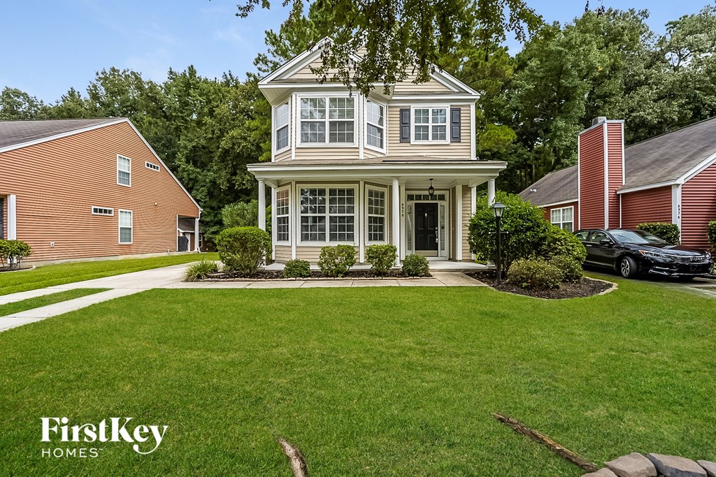 A house with a well-manicured lawn and a car parked in the driveway.
