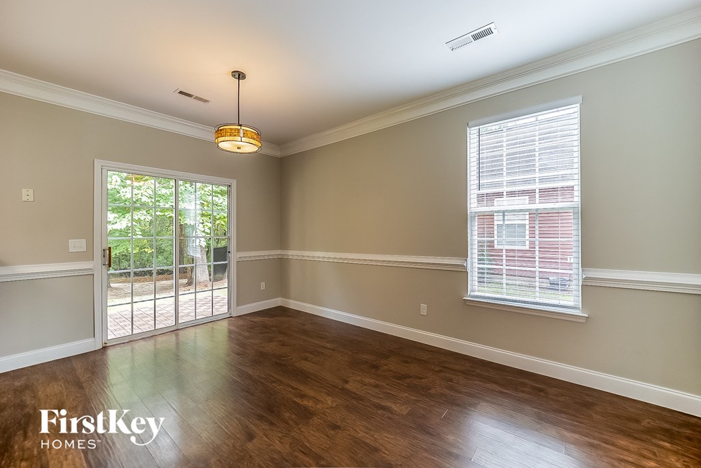 A room with wooden floors and a window with blinds.