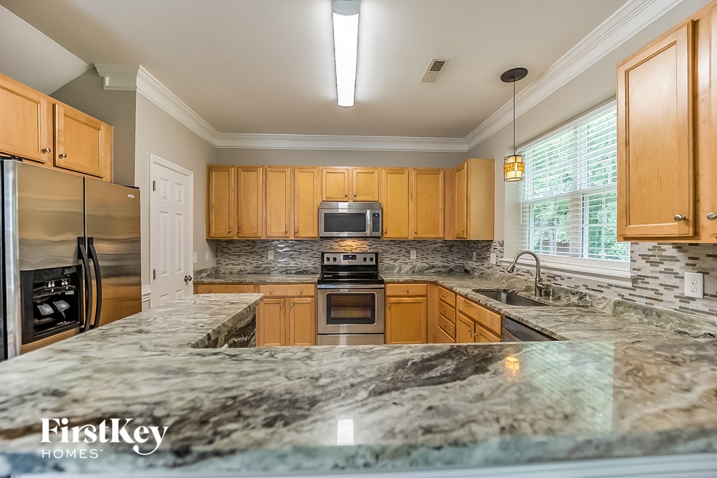 A kitchen with granite countertops and wooden cabinets.