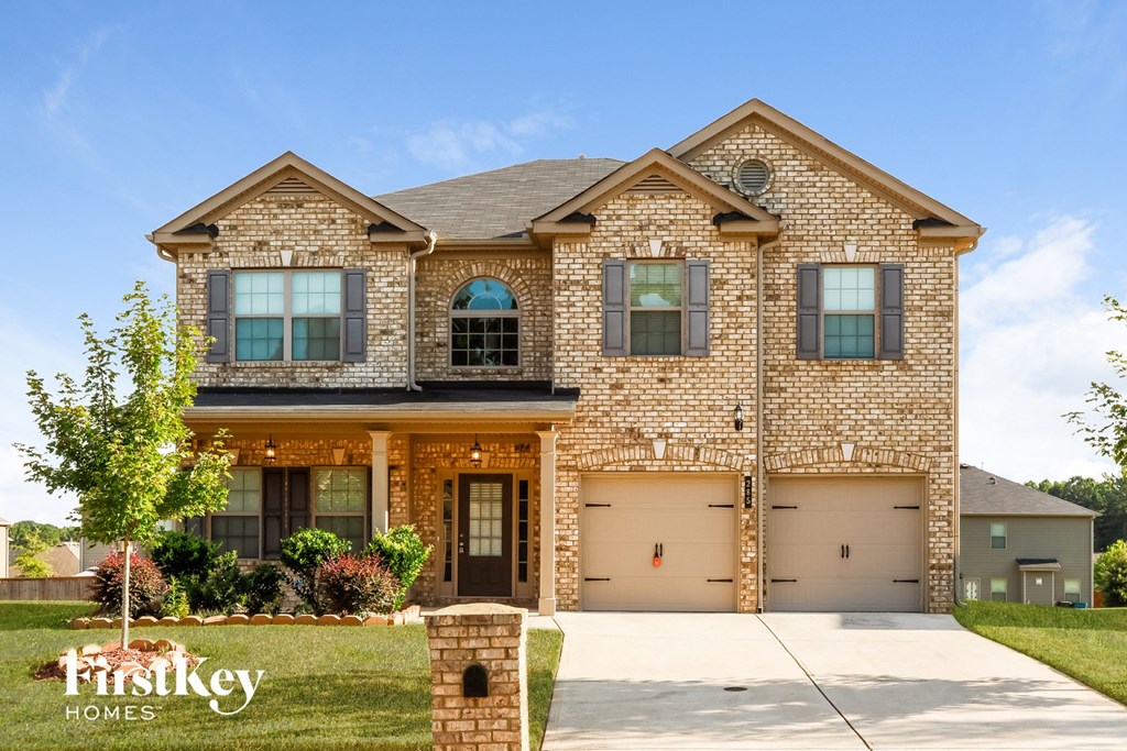 A brick house with a garage is for sale.