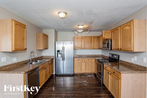 A kitchen with wooden cabinets and a stainless steel refrigerator.