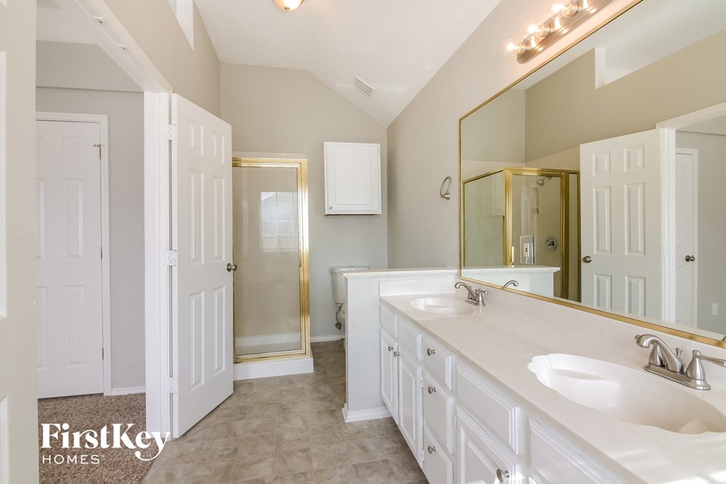 a white bathroom with two sinks and a shower