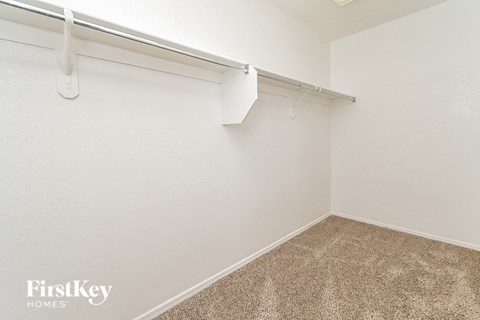 the spacious closet in the master bedroom of a manufactured home with white walls and carpet
