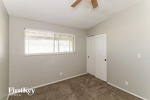a bedroom with carpet and a window and a door