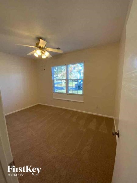 an empty room with a ceiling fan and a window