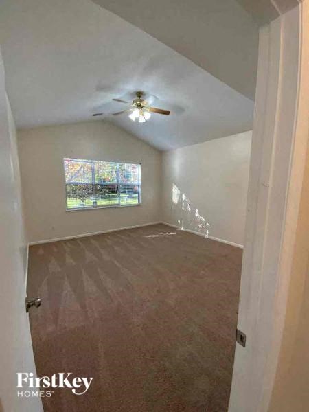 an empty room with a ceiling fan and a window