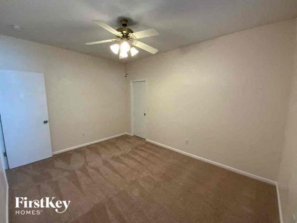 an empty living room with a ceiling fan