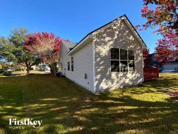 a small white house with a yard and trees
