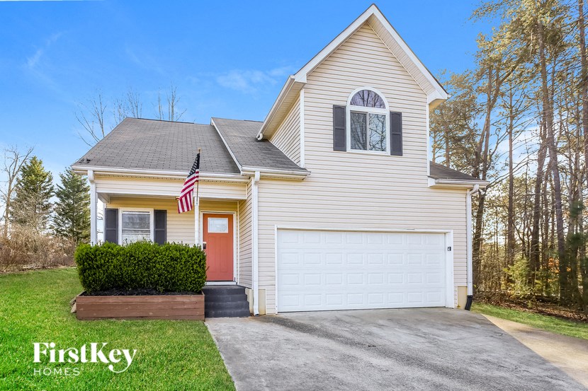 A house with a red door and a garage is for sale.